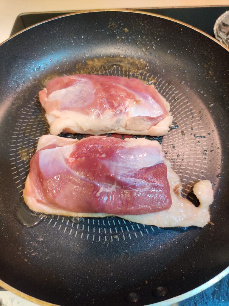 showing the skin side down of the duck breast when searing 