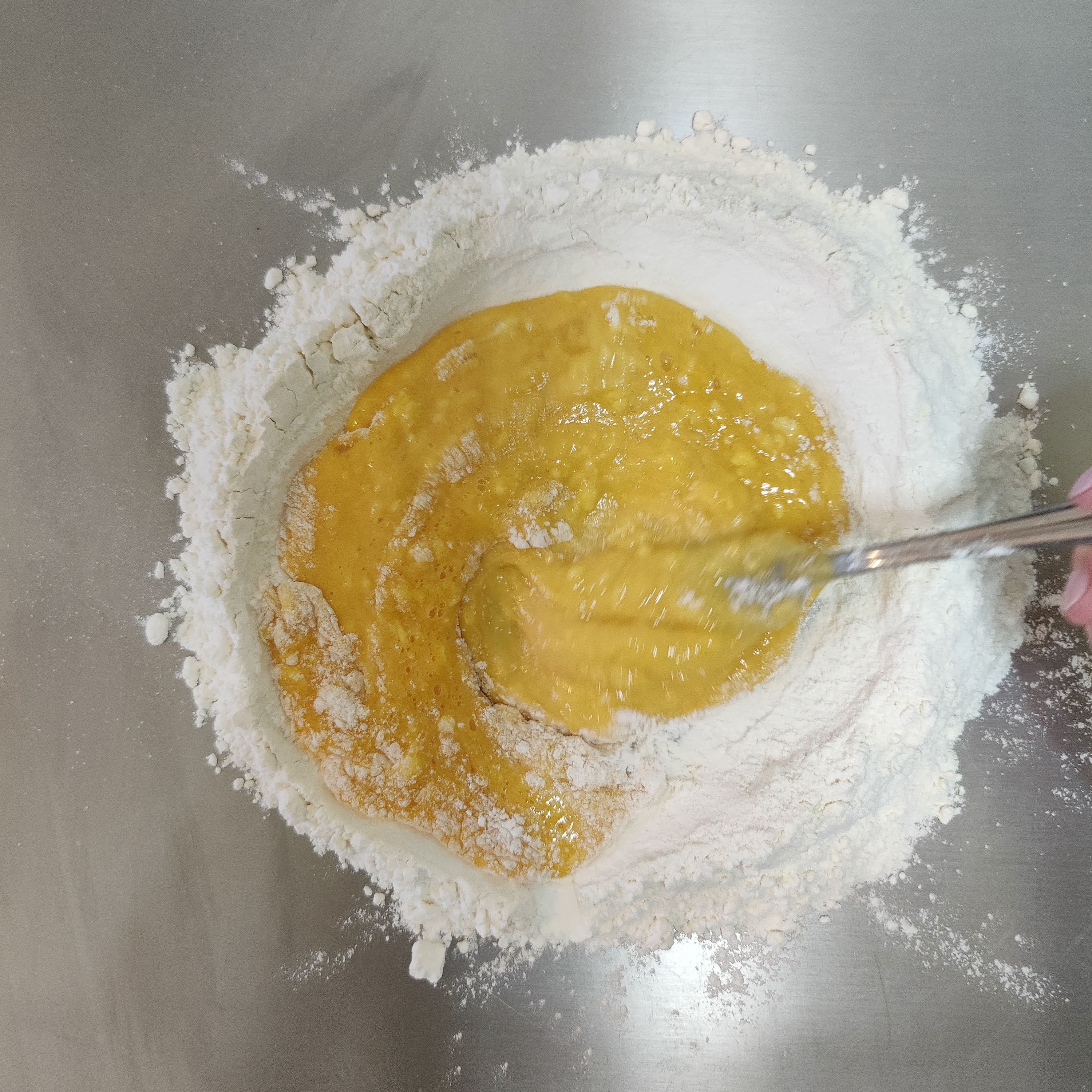 Whisking egg into flour 