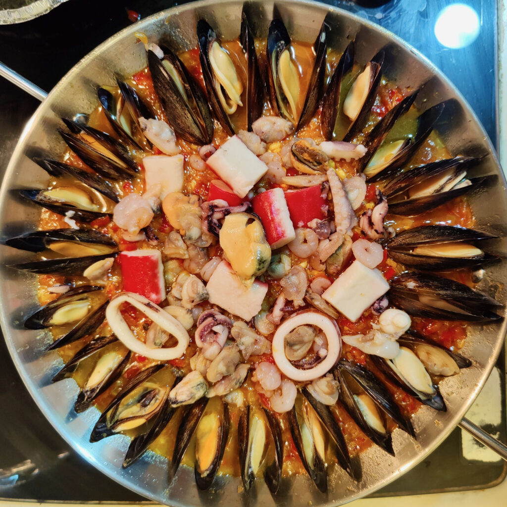 Decorate the paella with seafood